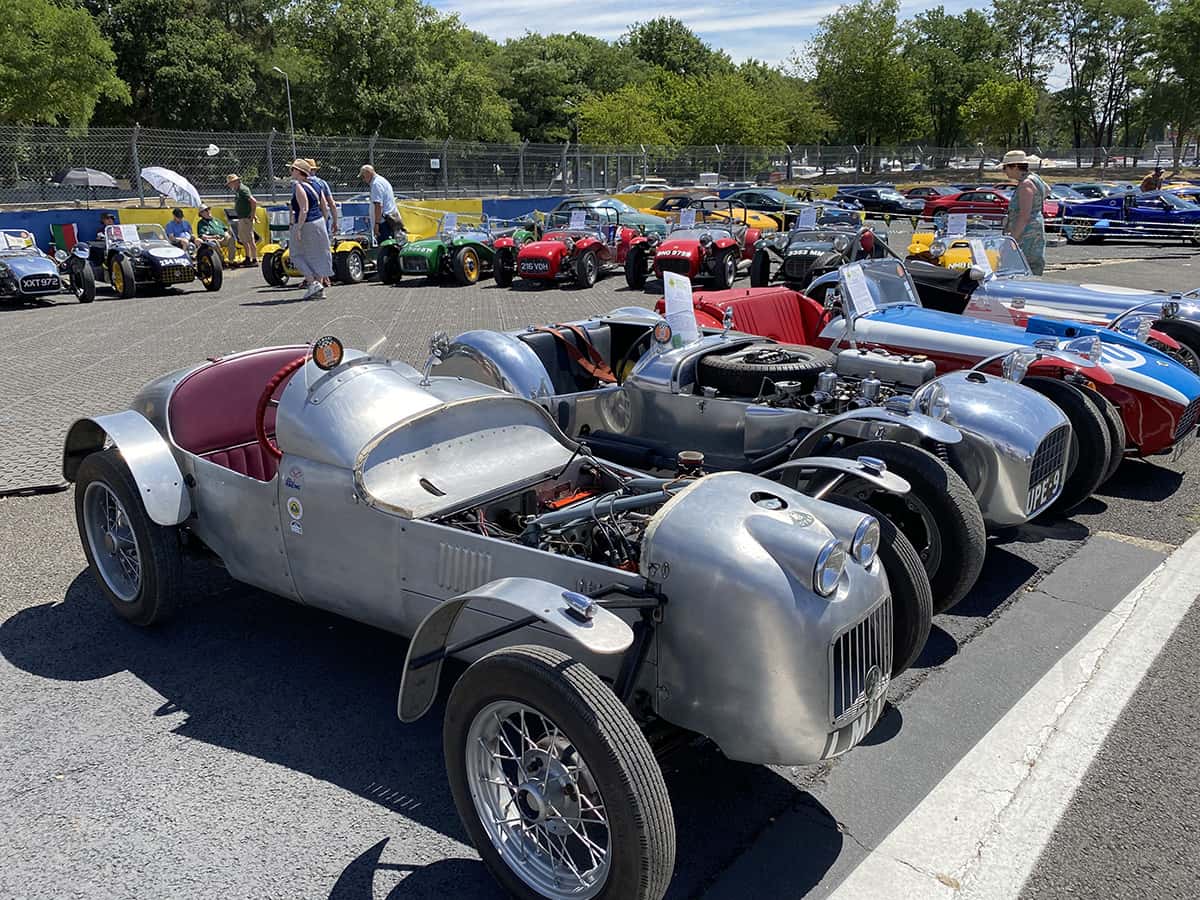 Rangée d’ultra‑légères style Lotus Seven en aluminium brut exposées au Mans Classic 2025.