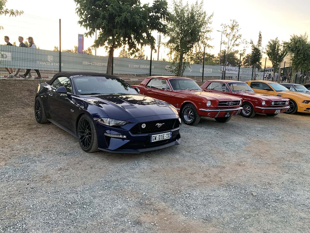 Mustang GT cabrio 2018 devant trois Mustang 1965 et un coupé moderne, Mans Classic 2025.