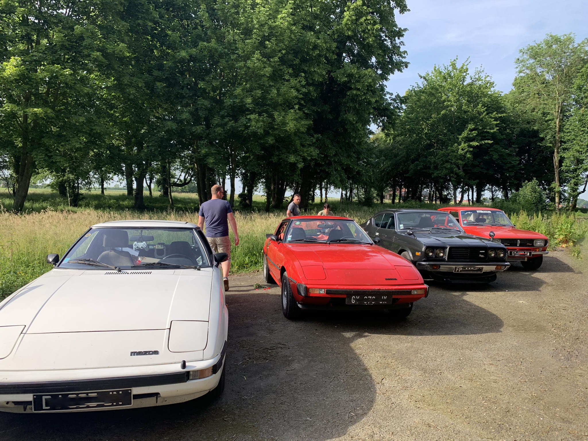 Classic Rotary Day 2026 - les Very Classics : RX-7 SA22, RX-4 et Eunos Cosmo sur l'aérodrome de Niergnies Very Classics du Classic Rotary Day 2026 alignés sur l'aérodrome de Niergnies - Mazda RX-7 SA22 blanche de 1980, RX-7 SA22 rouge de 1981, RX-4 noire de 1977 et RX-2 rouge en arrière-plan