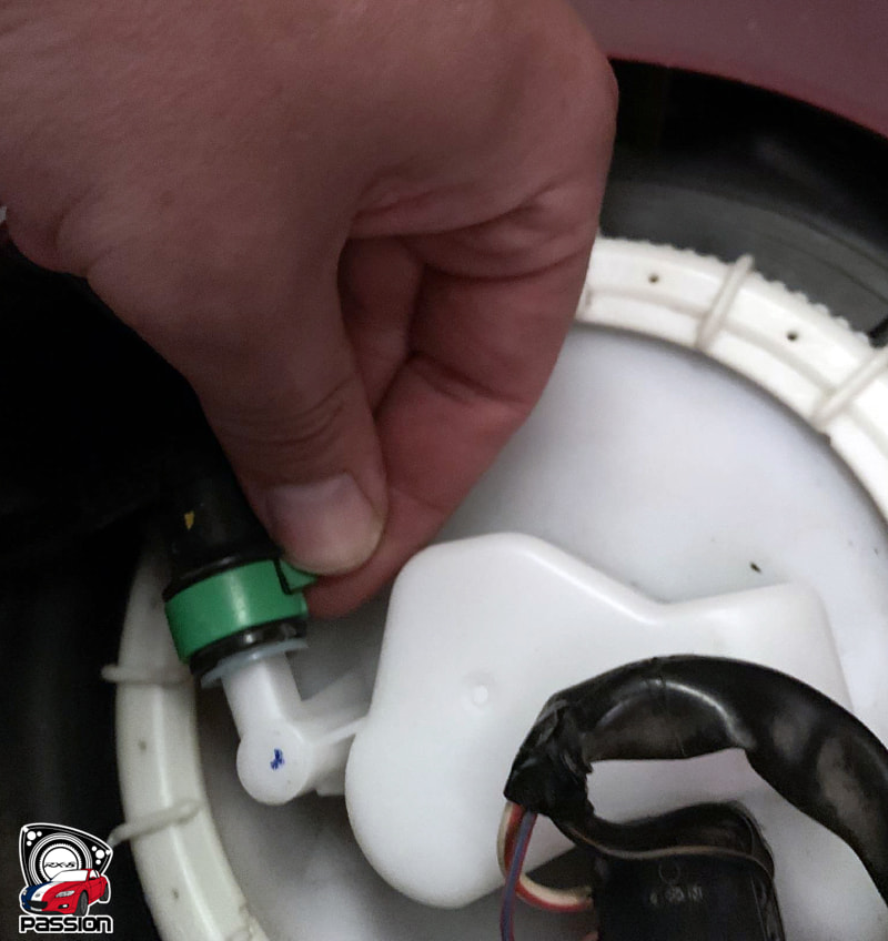 Pression du pouce sur le clip vert pour d&eacute;brancher le tuyau de carburant de la pompe &agrave; essence Mazda RX-8